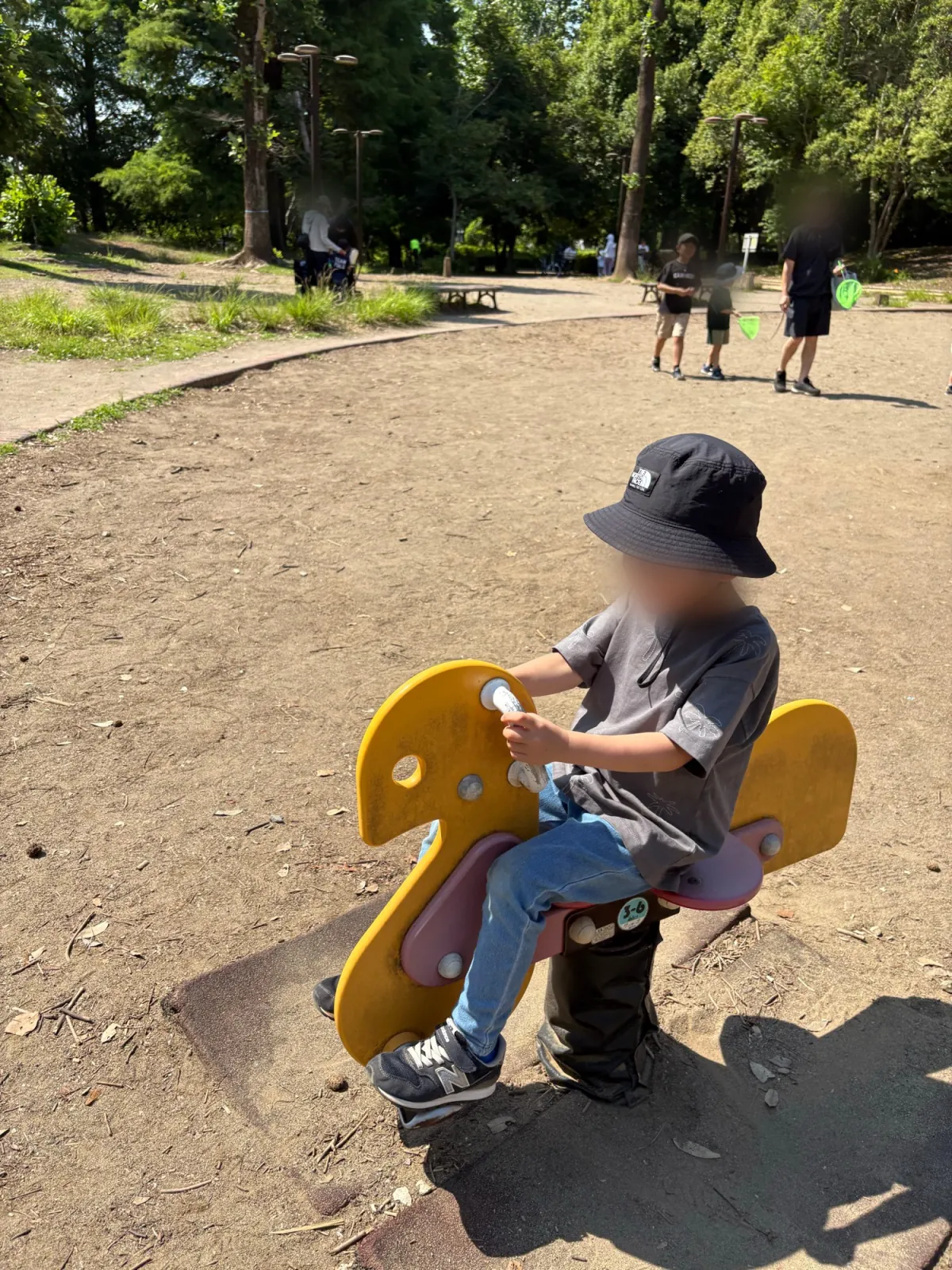 公園で帽子をかぶって遊ぶ子ども