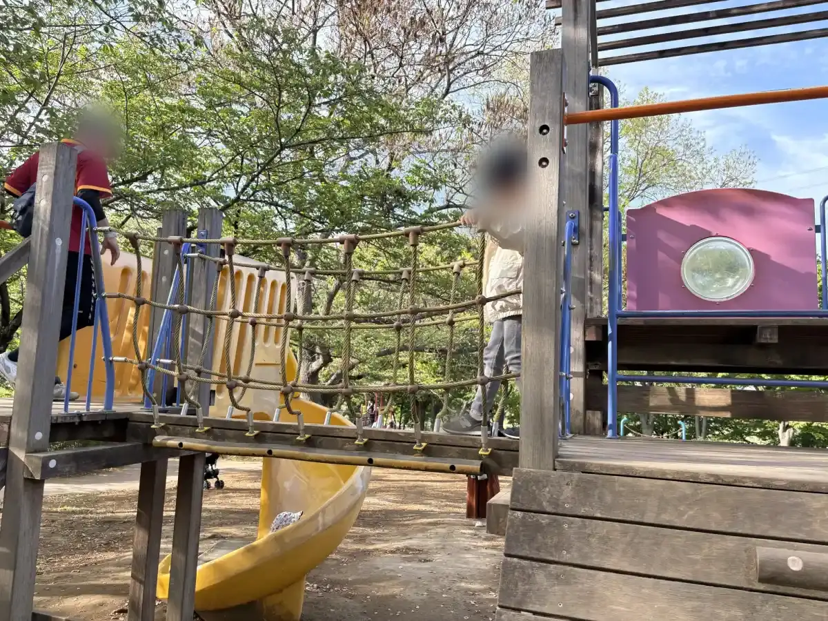 複合遊具の橋を慎重に渡る子ども