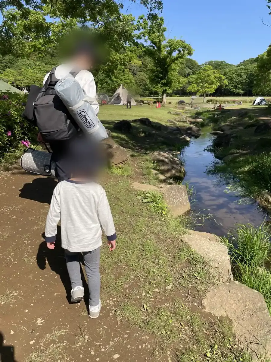 子どもと小川の近くを歩く様子