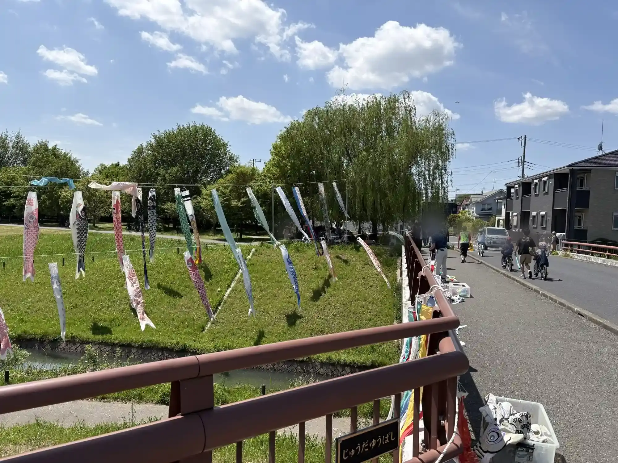 橋の上で鯉のぼりを設置している様子